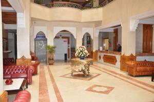 un vestíbulo con sofás y una mesa con flores. en Golden Beach Appart'hotel, en Agadir
