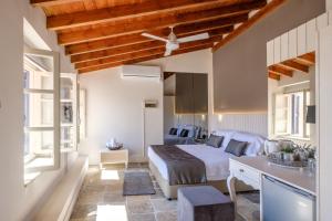 a bedroom with a bed and a desk and windows at Limassol Old Town Mansion in Limassol