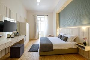 a bedroom with a large bed and a television at Limassol Old Town Mansion in Limassol