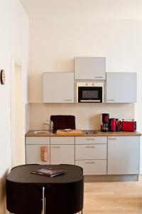 a kitchen with white cabinets and a black table at Ferienwohnung Klosterstraße direkt am Schloß in Schwerin
