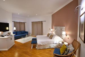 een slaapkamer met een bed en een woonkamer bij Tsilaosa Hôtel in Cilaos