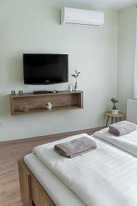 - une chambre avec 2 lits et une télévision à écran plat dans l'établissement Pisztácia apartman, à Eger