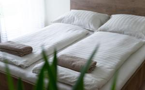 - un lit avec 2 oreillers et des serviettes dans l'établissement Pisztácia apartman, à Eger