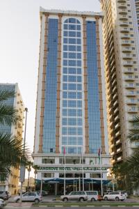a large building with cars parked in front of it at Mangrove Hotel in Ras al Khaimah