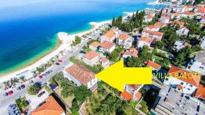 una vista aérea de una ciudad con una flecha amarilla en Apartments Balote, en Trogir