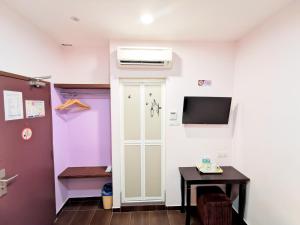 a room with a door and a tv and a table at Palazzo Hotel Kulai in Kulai