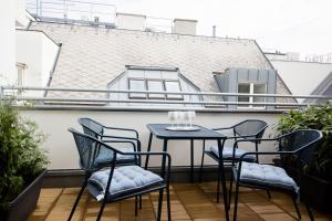 patio z krzesłami i stołem na balkonie w obiekcie Studio Apartments Opera - Mai's Apartments w Wiedniu