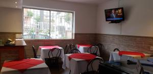 un restaurante con mesas y sillas y TV en la pared en Hostal del Centro Concepción, en Concepción