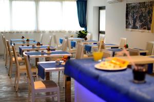 a cafeteria with tables and chairs with food on them at Aparthotel Tiziano in Grado