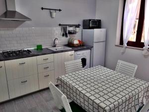 a kitchen with a table and a sink and a refrigerator at Alley 8 in Scilla