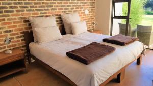 Una cama con dos almohadas encima. en Esther's Country Lodge, en Hekpoort