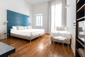 a bedroom with a white bed and a blue headboard at Hotel Piazza Bellini & Apartments in Naples