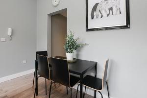 a dining room with a black table and chairs at Arena Apartments - Stylish and Homely Apartments by the Ice Arena with Parking in Nottingham