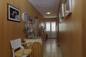 einen Flur mit einem Tisch, Stühlen und einer Uhr in der Unterkunft Rooms Mirjana - Centre of Trogir in Trogir