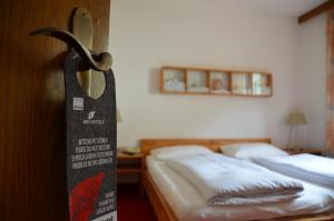 een kamer met twee bedden en een bord op de deur bij Landhotel Anna in Silandro