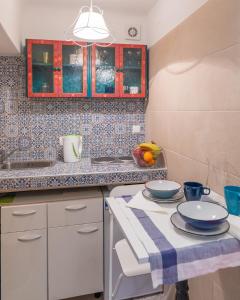 a kitchen with white cabinets and a table with two plates at The Art Republic, Old Town in Dubrovnik