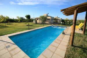 a blue swimming pool in a yard with a house at Cabañas EcoNature in Valle Grande