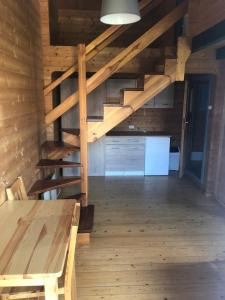 Habitación con suelo de madera y escaleras en una cabaña en Domki Letniskowe Bartek, en Rewal