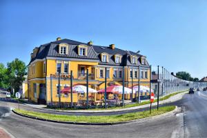 a yellow building with umbrellas in front of it at U Schabińskiej - Jedzenie i Spanie w Jaśle in Jasło