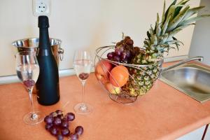 a bowl of fruit and wine glasses on a counter at Rainbow 1 Holiday Complex in Sunny Beach