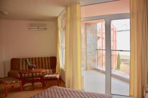 a bedroom with a bed and a sliding glass door at Rainbow 1 Holiday Complex in Sunny Beach