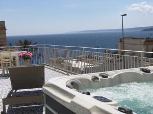una vasca idromassaggio su un balcone con vista sull'oceano sullo sfondo di Villa Cesarea Dimora di Charme a Santa Cesarea Terme