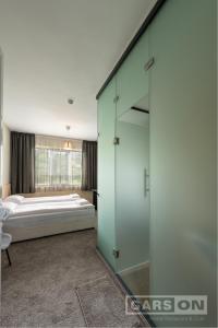 - une chambre avec un lit et un mur en verre dans l'établissement GarsON, à Kardjali