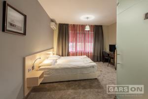 a hotel room with a bed and a desk at GarsON in Kŭrdzhali