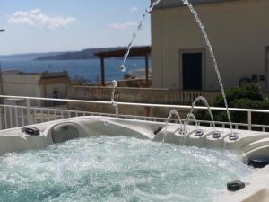 uma banheira com duas torneiras e água em Villa Cesarea Dimora di Charme em Santa Cesarea Terme