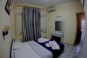 a bedroom with a bed and a table and a mirror at Minas Apartments in Hersonissos