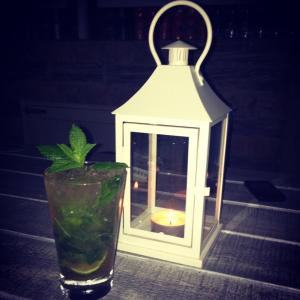 a lantern with a drink and a candle in a glass at Minas Apartments in Hersonissos