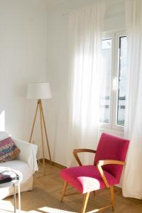 uma sala de estar com um sofá, uma cadeira e uma janela em My Megaro Flat em Atenas