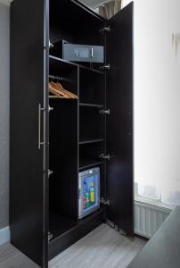 a black cupboard with a tv in it at NL Hotel District Leidseplein in Amsterdam