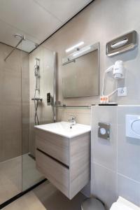 a bathroom with a sink and a shower at NL Hotel District Leidseplein in Amsterdam +35 photos