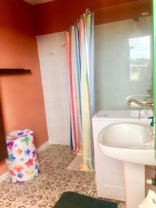 y baño con cortina de ducha y lavamanos. en Finca Arcoíris Tenerife VV, en Guía de Isora