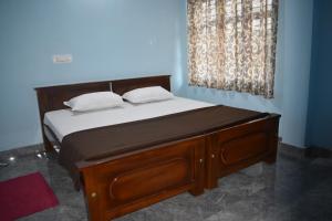 a bed with two pillows on it in a room at Srishti Homestay in Madikeri