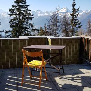a wooden table and a chair sitting on a patio at La casa di Pila in Pila