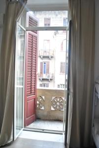 una ventana abierta con vistas a un edificio en Sunrise Hostel & Rooms, en Palermo