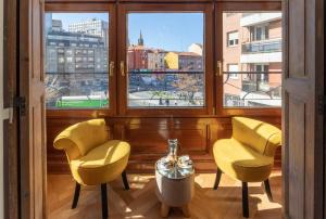Habitación con 2 sillas amarillas y ventana en Acogedor, de Diseño Moderno en Zona Antigua, en Bilbao