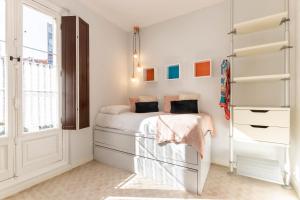 Habitación blanca con cama y ventana en Acogedor, de Diseño Moderno en Zona Antigua, en Bilbao