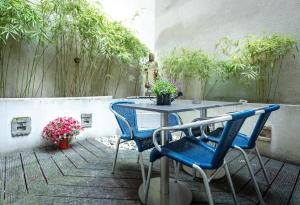 een tafel en stoelen op een patio met planten bij NL Hotel District Leidseplein in Amsterdam