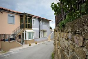 eine Straße mit Häusern und einer Mauer und einem Bürgersteig in der Unterkunft Apartmaji Hrvatin v Kortah in Izola