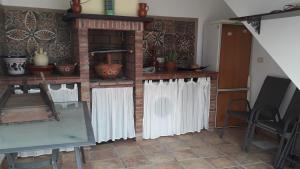 a room with white curtains and a brick fireplace at Casa Campanilla. Valle de abdalajis in Valle de Abdalagís