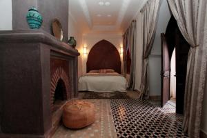 a bedroom with a fireplace with a bed in it at Riad Tahar Oasis in Marrakesh