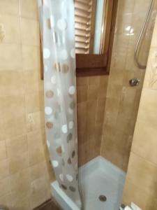 eine Dusche mit einem weißen Duschvorhang im Bad in der Unterkunft Pis Gran i Acollidor amb LLar de Foc, a Camprodon in Camprodon