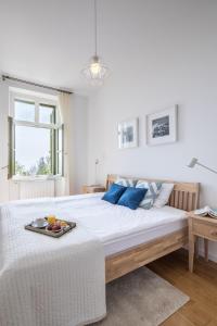 a white bedroom with a large bed with a tray on it at Millennium Suite in Balatonfüred