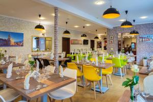 a restaurant with wooden tables and yellow chairs at Hotel Topaz Poznań Centrum in Poznań