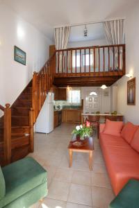 a living room with a couch and a staircase at Morpheas Apartments in Plakias