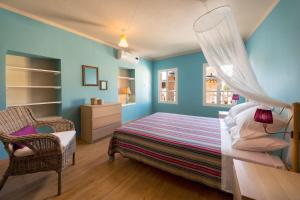 a bedroom with blue walls and a bed and a chair at Colourful Home, Medieval Town Rhodes in Rhodes Town