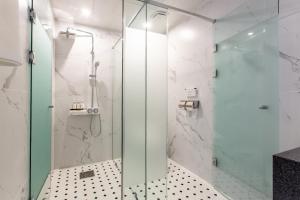 baño con ducha y puerta de cristal en Brown Dot Gijang Yeonhwari en Busan